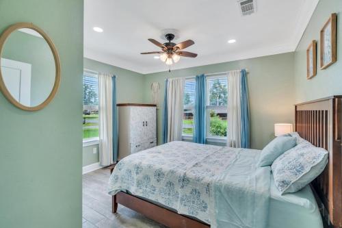 a bedroom with a bed with a ceiling fan and a mirror at River Cottage near the Airport in Saint Rose