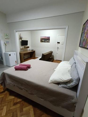 a bedroom with a bed and a desk with a computer at Lindo Loft na Cinelândia in Rio de Janeiro