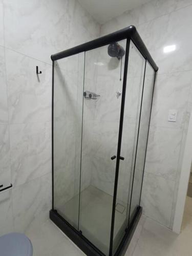 y baño con ducha y puerta de cristal. en Lindo Loft na Cinelândia en Río de Janeiro