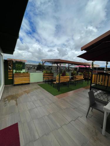 um pátio com bancos e mesas no telhado em SARA HOTEL IBARRA em Ibarra