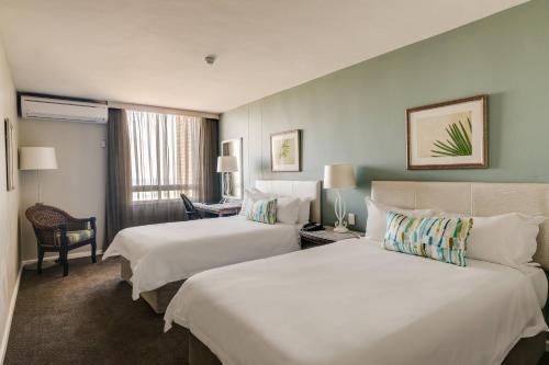a hotel room with two beds and a desk at Protea Hotel by Marriott Karridene Beach in Amanzimtoti