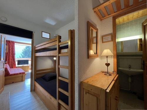 a bedroom with bunk beds and a bathroom with a sink at Appartement Peisey-Nancroix-Plan Peisey, 1 pièce, 4 personnes - FR-1-757-79 in Peisey-Nancroix
