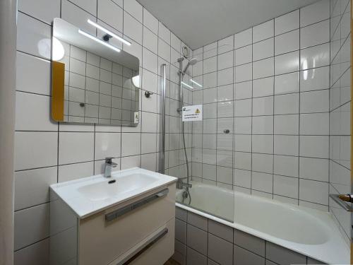 a bathroom with a sink and a tub and a mirror at Appartement Peisey-Nancroix-Plan Peisey, 3 pièces, 6 personnes - FR-1-757-71 in Peisey-Nancroix