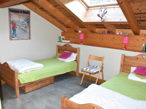 une chambre avec deux lits et une chaise dedans dans l'établissement Grand appart. 4 pièces, mezzanine, 3 sdb, poêle, proche pistes - FR-1-464-222, à Pralognan-la-Vanoise