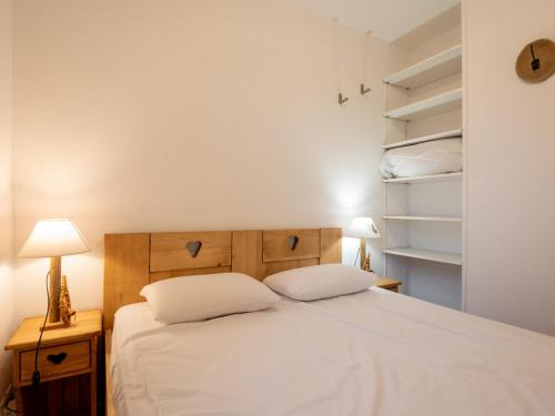 een slaapkamer met een bed met 2 kussens en planken bij Appartement Valfréjus, 3 pièces, 7 personnes - FR-1-468-118 in Modane