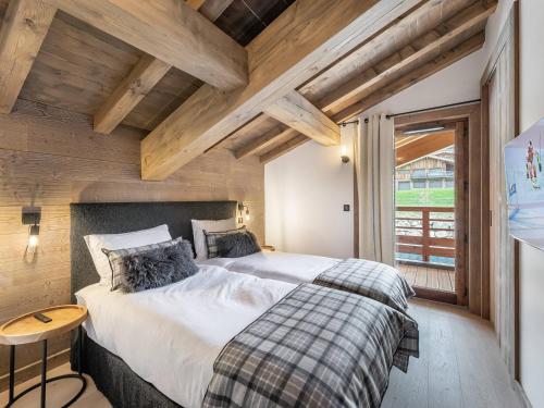 une chambre avec un grand lit dans une pièce avec des plafonds en bois dans l'établissement Luxueux Appartements au Pied du Mont d'Arbois, Megève, avec Espace Bien-Être et Salle de Cinéma - FR-1-569-106, à Megève