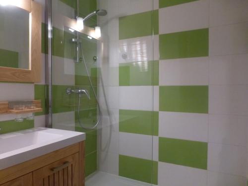 uma casa de banho verde e branca com um chuveiro e um lavatório em Appartement Peisey-Vallandry, 1 pièce, 4 personnes - FR-1-757-84 em Landry