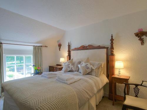 a bedroom with a large bed with white sheets at Henfaes Isaf in Cynwyd
