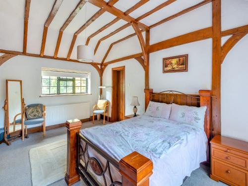 a bedroom with a wooden bed in a room at Gardeners Cottage in Kelvedon Hatch