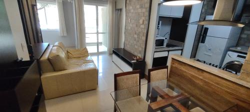een woonkamer met een bank en een tafel bij The Sun Resort - Super Apartamento de 2 quartos - 1 suíte e 1 reversível in Brasilia