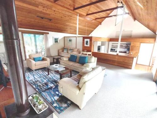 ein Wohnzimmer mit 2 Sofas und einem Tisch in der Unterkunft Lake Russell Retreat in Emerald Beach