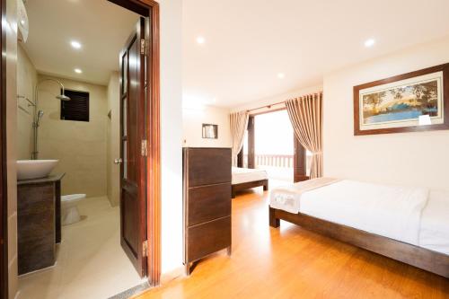 a bedroom with a bed and a bathroom at B'Lan Riverside Villa in Hoi An