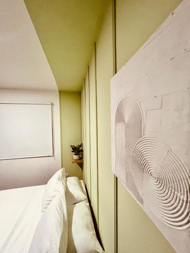 a bedroom with a white bed and a wall with a fan at La Casa de colour Filandia, Quindio in Filandia