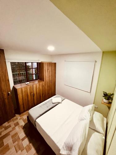 a bedroom with a white bed and a window at La Casa de colour Filandia, Quindio in Filandia
