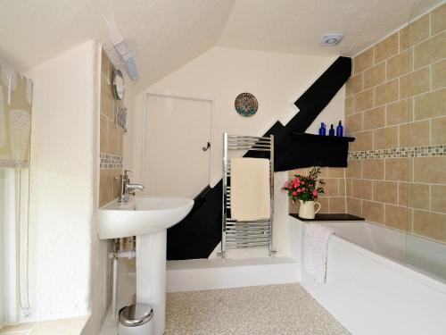 a bathroom with a sink and a bath tub at Henfaes Isaf in Cynwyd