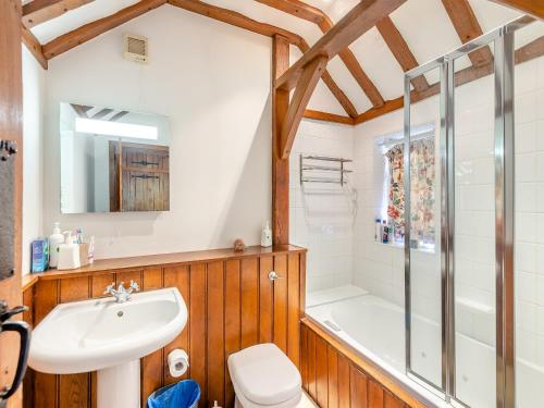 a bathroom with a shower and a toilet and a sink at Gardeners Cottage in Kelvedon Hatch