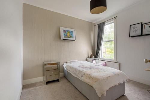 sypialnia z łóżkiem i oknem w obiekcie Inviting 3-Bed House in Beckenham w mieście Beckenham