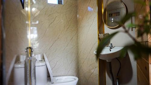 La salle de bains est pourvue de toilettes et d'un lavabo. dans l'établissement Dalat 1AM, à Xuan An