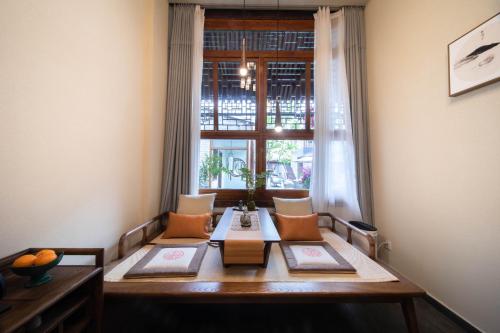 a dining room table with chairs and a window at Guipu Beihai Courtyard Hotel Beijing in Beijing