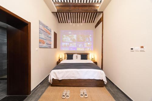 a bedroom with a bed and two pairs of slippers at Guipu Beihai Courtyard Hotel Beijing in Beijing