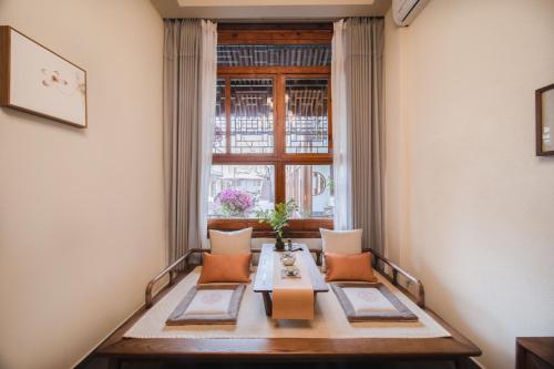 a dining room with a table and a window at Guipu Beihai Courtyard Hotel Beijing in Beijing