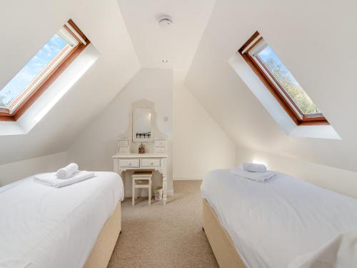 a attic bedroom with two beds and a mirror at Primrose Cottage- Uk45597 in Verwick