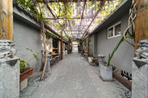 a walkway with trees and plants in a building at Guipu Beihai Courtyard Hotel Beijing in Beijing