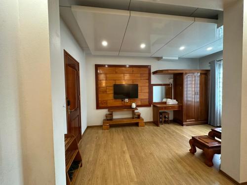 uma sala de estar com televisão e uma parede de madeira em khách sạn thúy phương 2 em Hào Gia