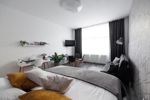 a white bedroom with a bed and a desk at Gemütliches App. Messe / Prater in Vienna