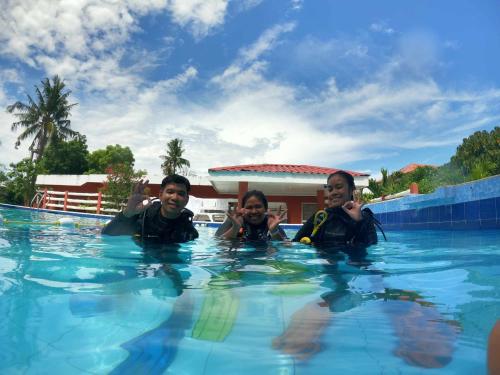 a group of three men in a swimming pool at Malapascua Beach and Dive Resort in Logon
