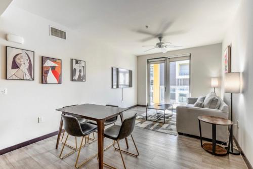 een woonkamer met een tafel en stoelen en een bank bij New WeHo Luxury Apartment in Los Angeles