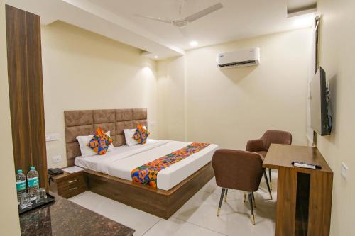 a bedroom with a bed and a desk and a television at FabHotel Prism Grand in Zirakpur