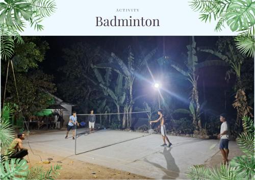 un grupo de hombres jugando al tenis en una pista por la noche en Rangsot Inn en Pawenang