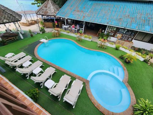 an overhead view of a swimming pool with chaise lounge chairs at Tiki Beach Koh Phangan Beach Restaurant Bar and Coworking in Ban Tai