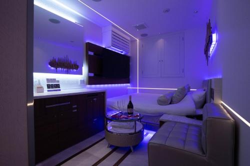 a living room with a white couch and purple lighting at Hotel Blanche 大人専用 in Tokyo