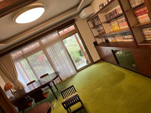 a room with a table and chairs in a library at 離れの宿　かぶろの庭 in Matsukawa