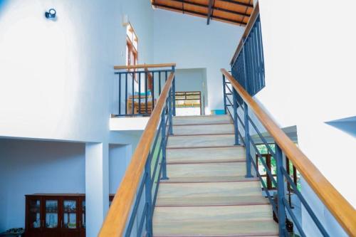 a staircase leading up to a building with blue ceilings at SaDev Lake Villa Bandaragama in Bandaragama