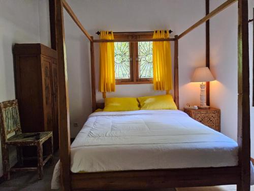 1 dormitorio con cama con dosel y ventana en Rumah atlas, en Mangsit
