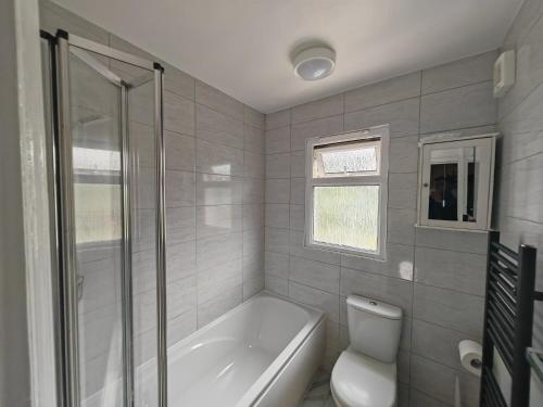 uma casa de banho com uma banheira, um WC e um chuveiro em Stylish 1 bedroom Haven em Coventry