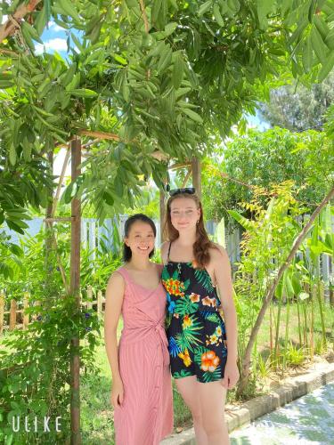 two girls standing next to each other under a tree at Laoxao Homestay in Hoi An
