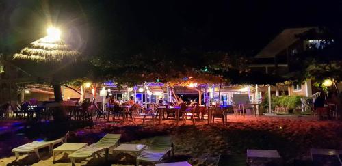 a group of people sitting at a restaurant at night at Malapascua Beach and Dive Resort in Logon