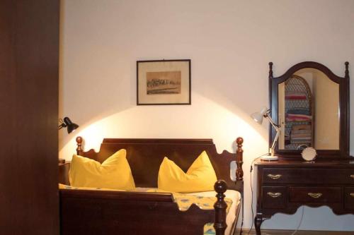 a bedroom with a bed with yellow pillows and a mirror at Stan u Zenici in Zenica