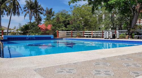 a swimming pool with blue water in front of a fence at Malapascua Beach and Dive Resort in Logon