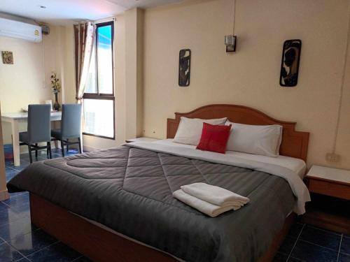 um quarto com uma cama grande com duas toalhas em Patong Rose Guest House em Patong Beach