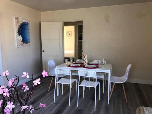 a dining room with a white table and chairs at Entire Lovely 3-Bedroom Home with 3 Queen Beds & Spacious Yard, 6 Guests Maximum in Chula Vista