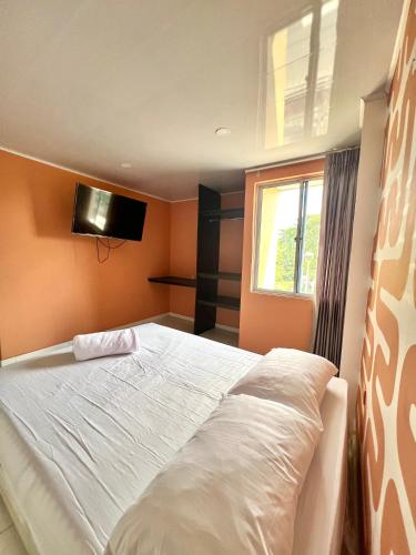 1 dormitorio con cama blanca y ventana en Hotel Paranawa en Baranoa
