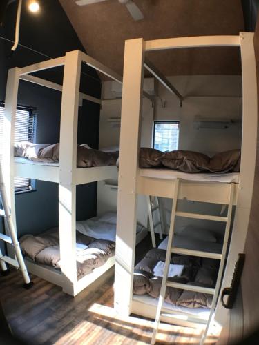 a room with three bunk beds in a room at LN13 貸切ゲストハウス三宮えびすや-Guest House Ebisuya- in Kobe