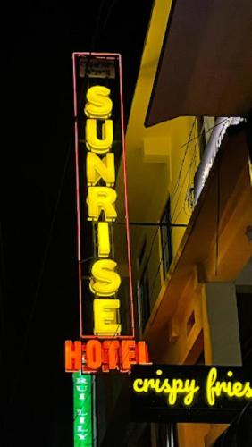 um sinal de néon ao lado de um hotel em Hotel Sunrise Imphal em Imphal