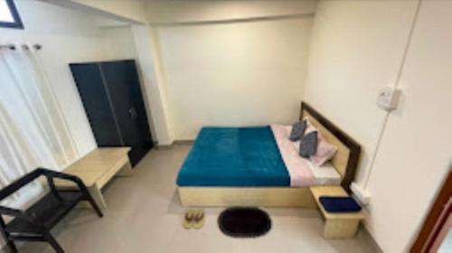1 dormitorio pequeño con 1 cama y 1 silla en Hotel Sunrise Imphal, en Imphal