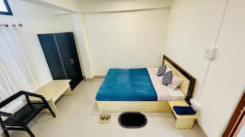 um pequeno quarto com uma cama e uma cadeira em Hotel Sunrise Imphal em Imphal